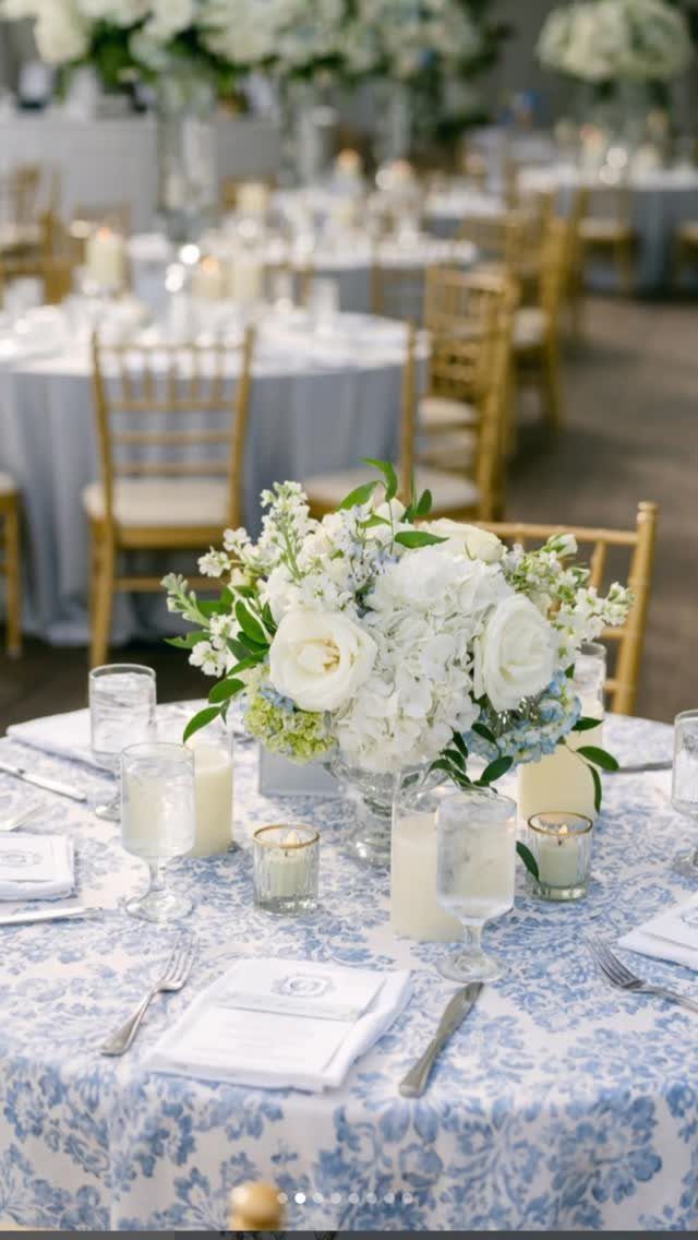 10 Blue Color Palette Wedding Ideas for Every Season 9 White and blue floral patterned tablecloth with a centerpiece of white roses and greenery.