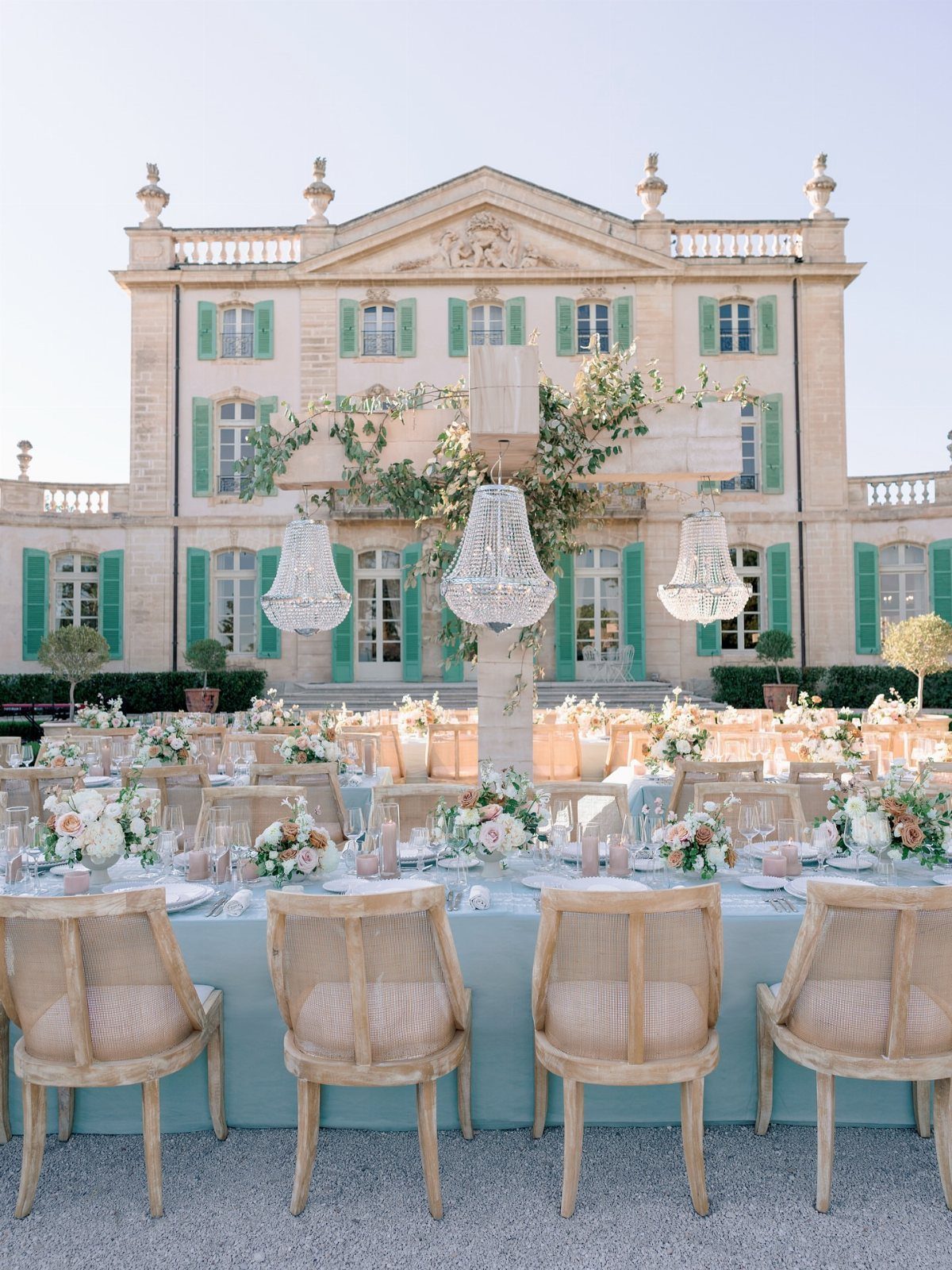 10 Blue Color Palette Wedding Ideas for Every Season 8 Wedding reception tables with light blue linens and floral centerpieces set before a grand mansion.