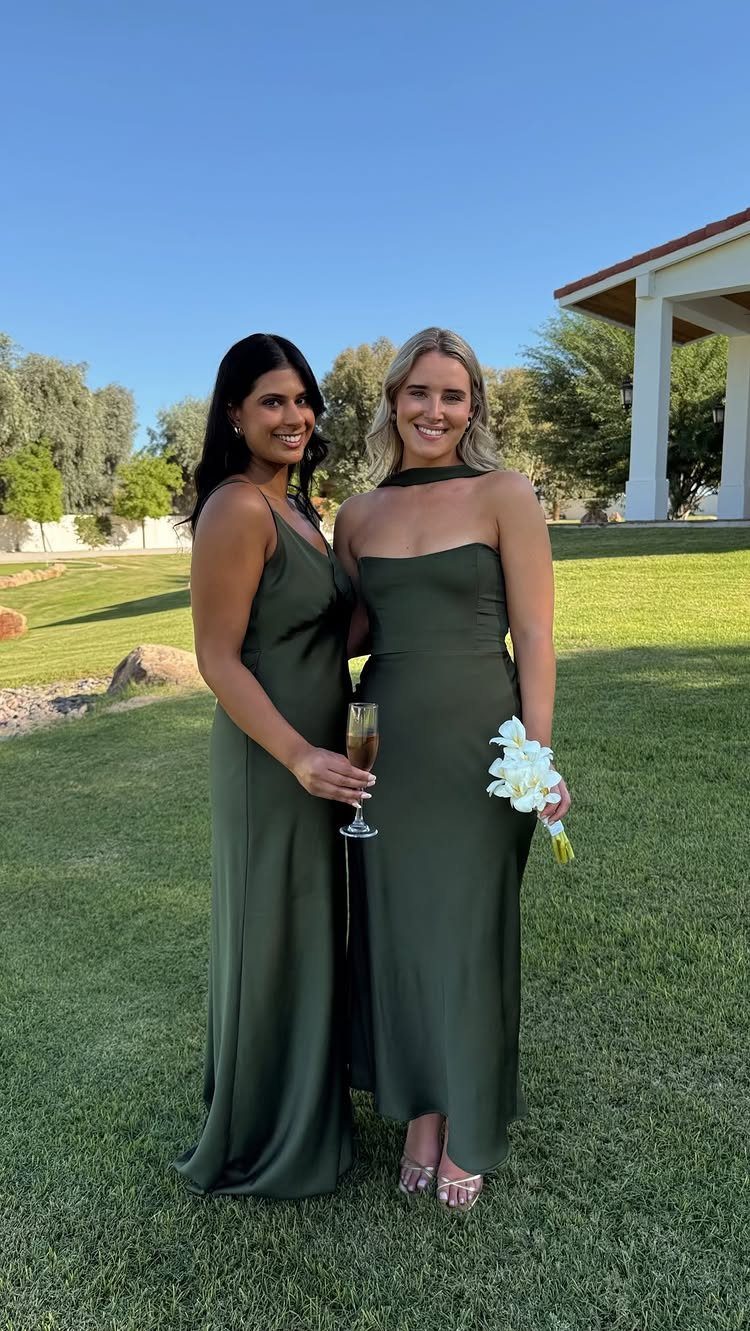 Dark Green Wedding: 13 Ideas for a Forest Reception 3 Two women in long dark green dresses standing on a sunny green lawn.