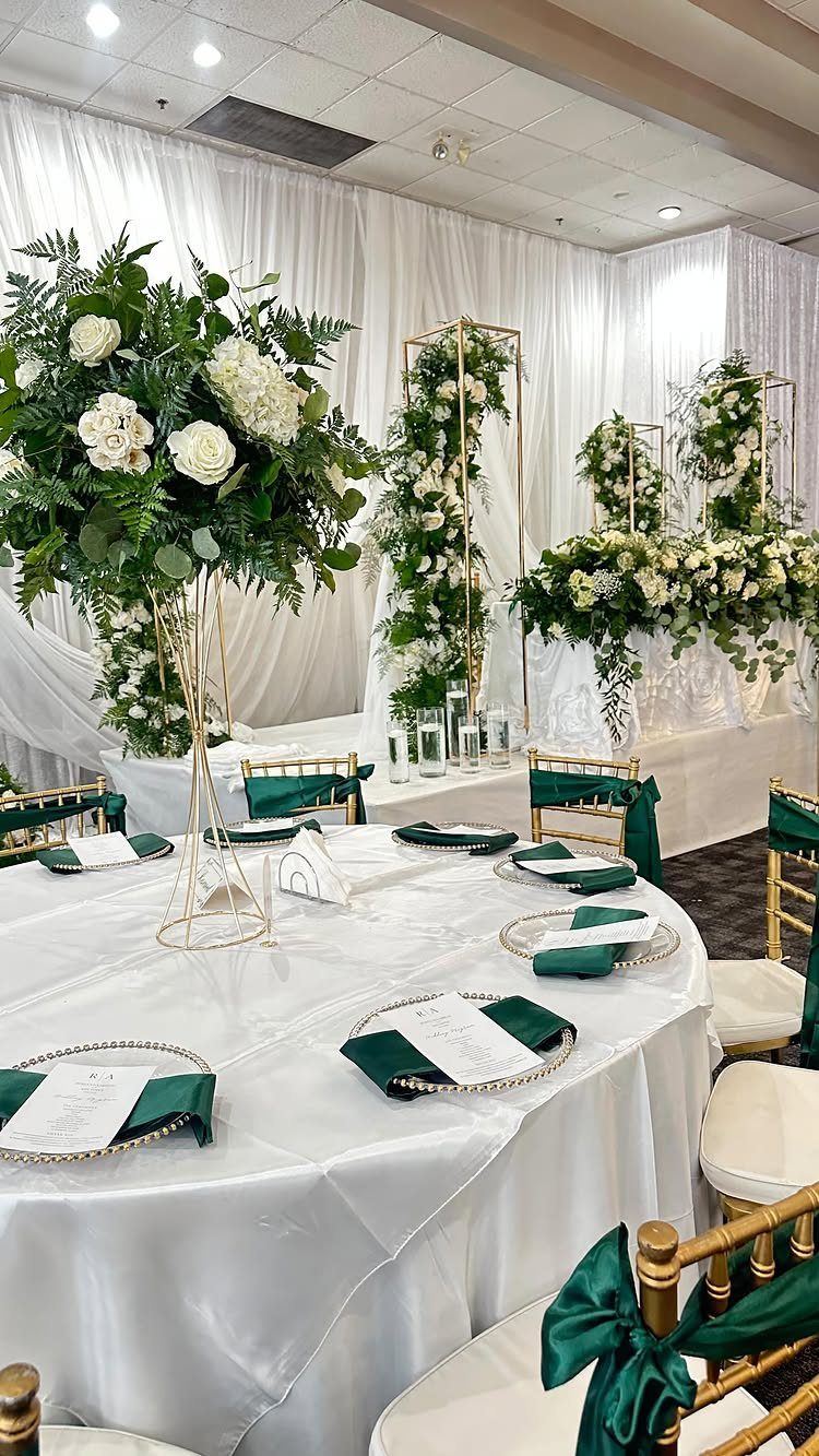 Dark Green Wedding: 13 Ideas for a Forest Reception 2 A wedding table set with white linens, green napkins, and a tall floral centerpiece with white roses.