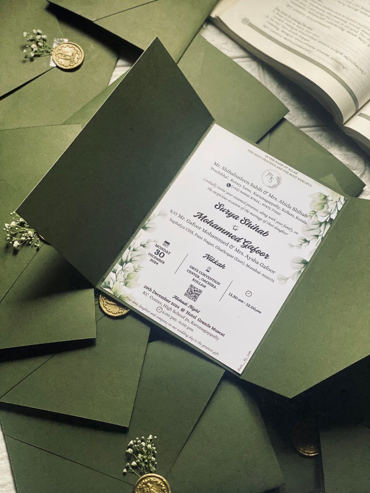 Dark Green Wedding: 13 Ideas for a Forest Reception 5 A white wedding invitation with green floral patterns inside a dark green envelope.