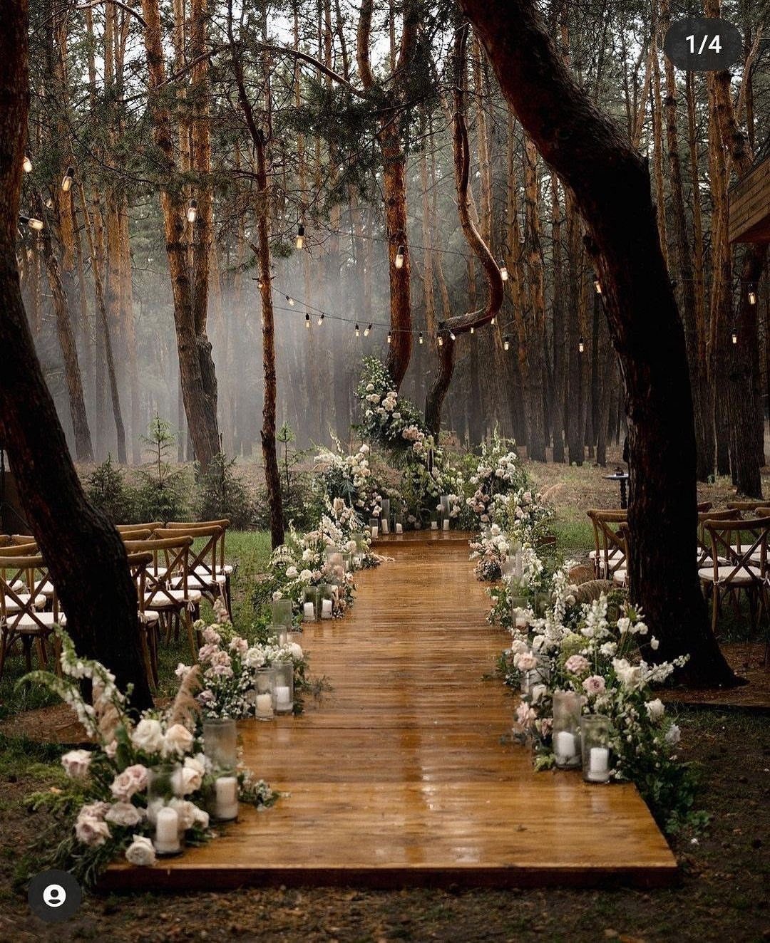 Enchanted Forest Wedding Theme: 10 Ideas for a Natural Setting 7 Wooden aisle lined with white flowers and candles leading through a misty forest with string lights.