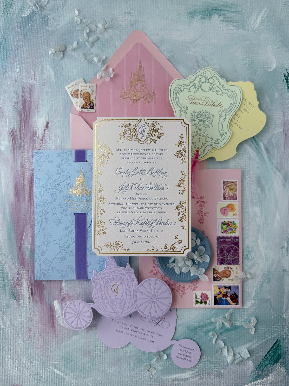 Pastel wedding invitations with gold foil details and a purple Cinderella carriage cutout.