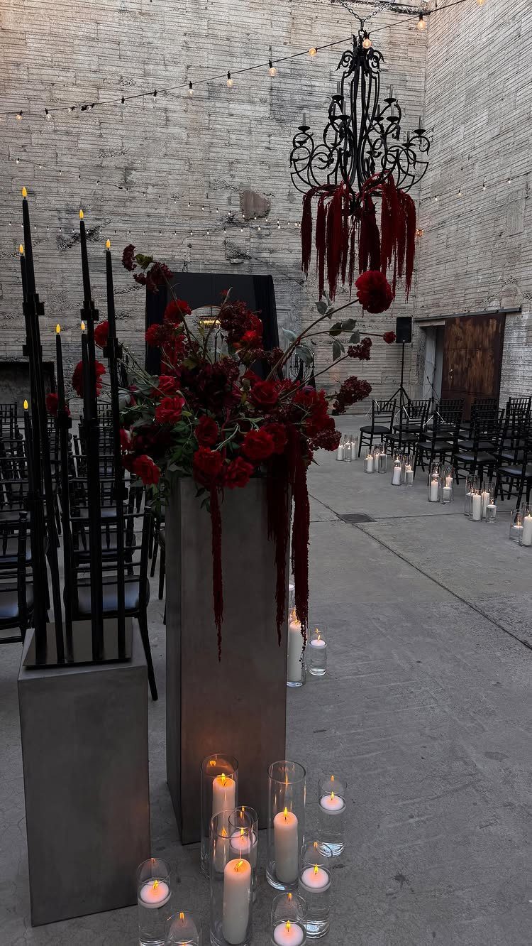 Gothic Wedding Theme: 11 Dark & Elegant Ideas 8 Red rose arrangements and black taper candles decorate a dark, gothic wedding ceremony aisle.