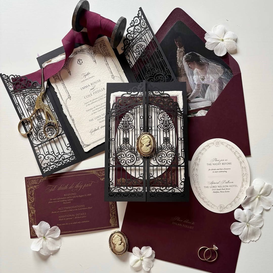 Gothic Wedding Theme: 11 Dark & Elegant Ideas 4 Gothic wedding invitations with black laser-cut patterns, burgundy envelopes, and white flowers on a white background.