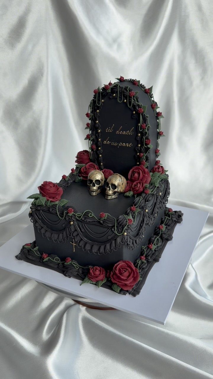 Gothic Wedding Theme: 11 Dark & Elegant Ideas 3 Black gothic wedding cake decorated with red roses, gold accents, and small skulls.