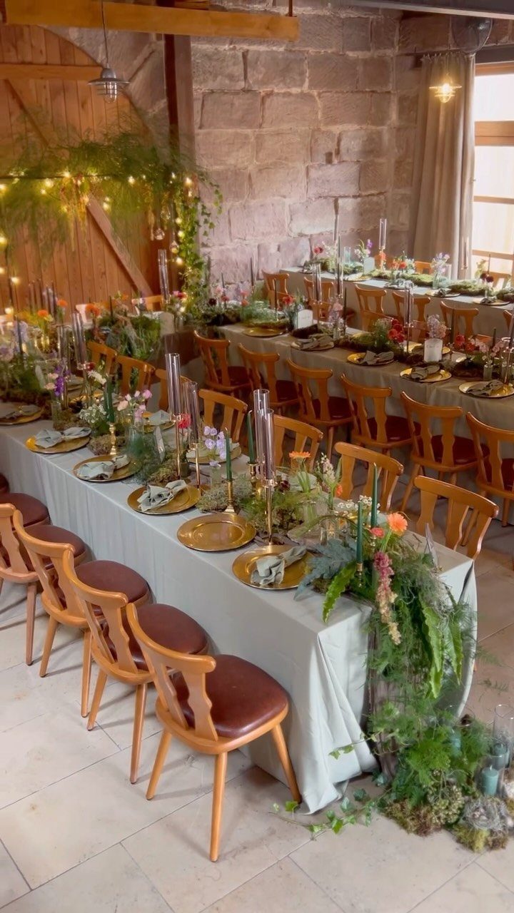 Hobbit Themed Wedding: 20 Ideas for Your Shire Celebration 16 Long banquet tables decorated with greenery and gold chargers in a rustic stone room.