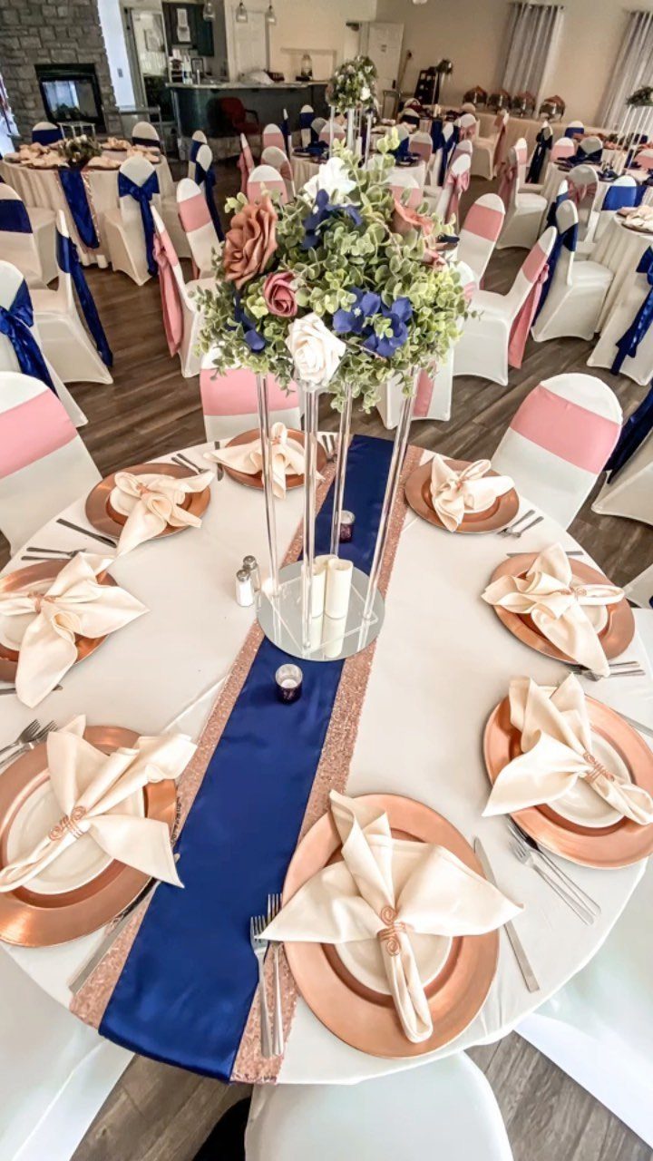 16 Navy Blue Wedding Theme Ideas for Every Part of Your Day 1 Wedding table setting featuring navy blue runner, rose gold chargers, and dusty rose floral centerpiece.