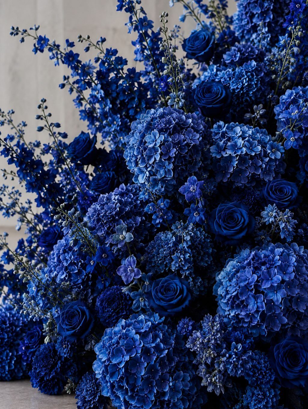 16 Navy Blue Wedding Theme Ideas for Every Part of Your Day 3 A lush arrangement of deep navy and cobalt blue roses and hydrangeas.