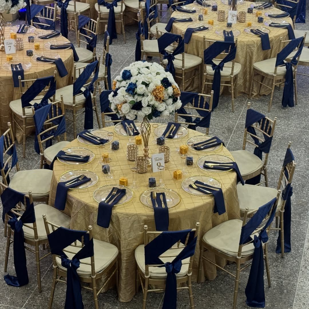 16 Navy Blue Wedding Theme Ideas for Every Part of Your Day 2 Gold banquet tables with navy blue napkins and white floral centerpieces in a ballroom.