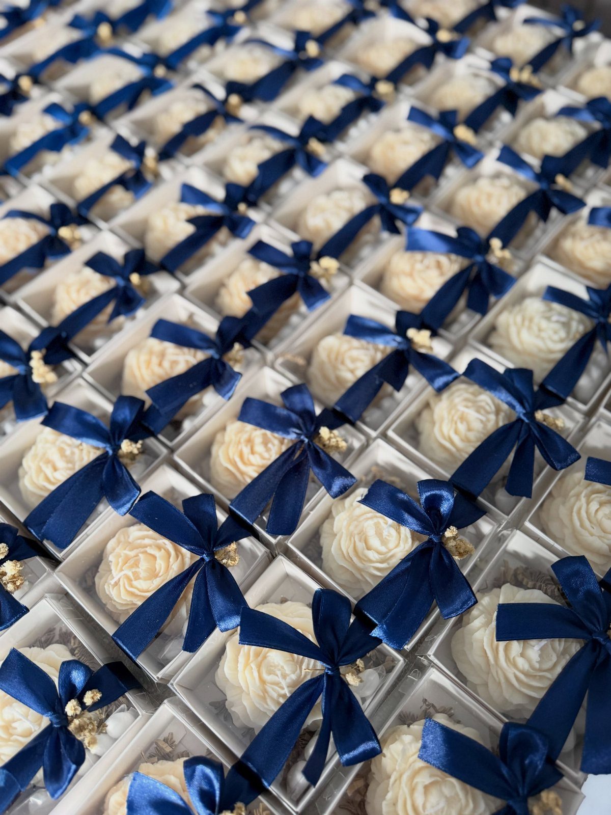 16 Navy Blue Wedding Theme Ideas for Every Part of Your Day 15 Rows of white cupcakes in clear boxes decorated with navy blue satin bows.