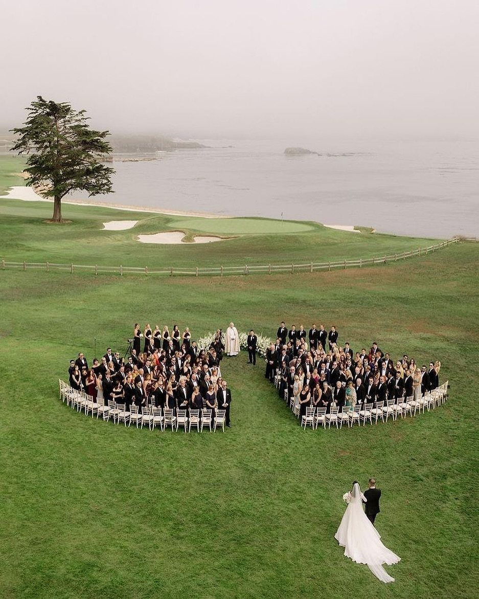19 Photosession Ideas for Your Wedding Ceremony 19 Aerial view of wedding guests seated on a green lawn overlooking the ocean.