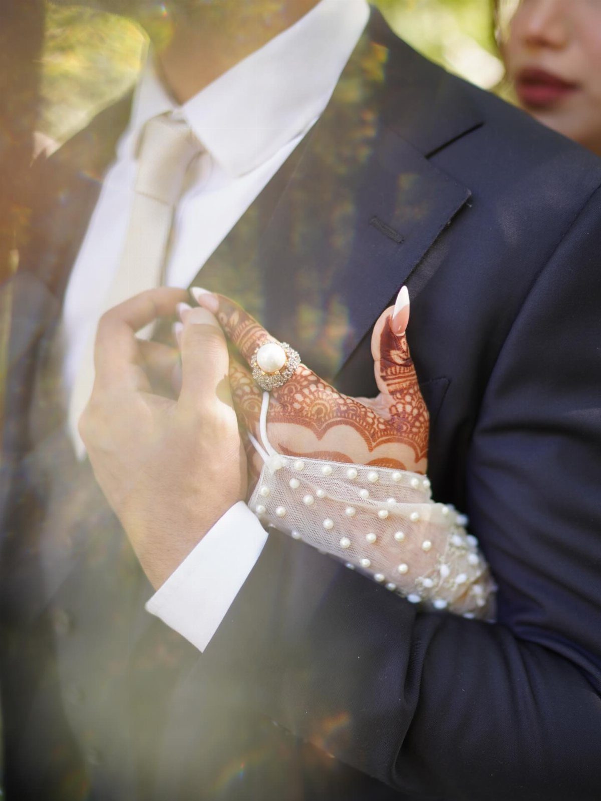 19 Photosession Ideas for Your Wedding Ceremony 15 Hands with henna and a pearl ring resting on a navy blue wedding suit.