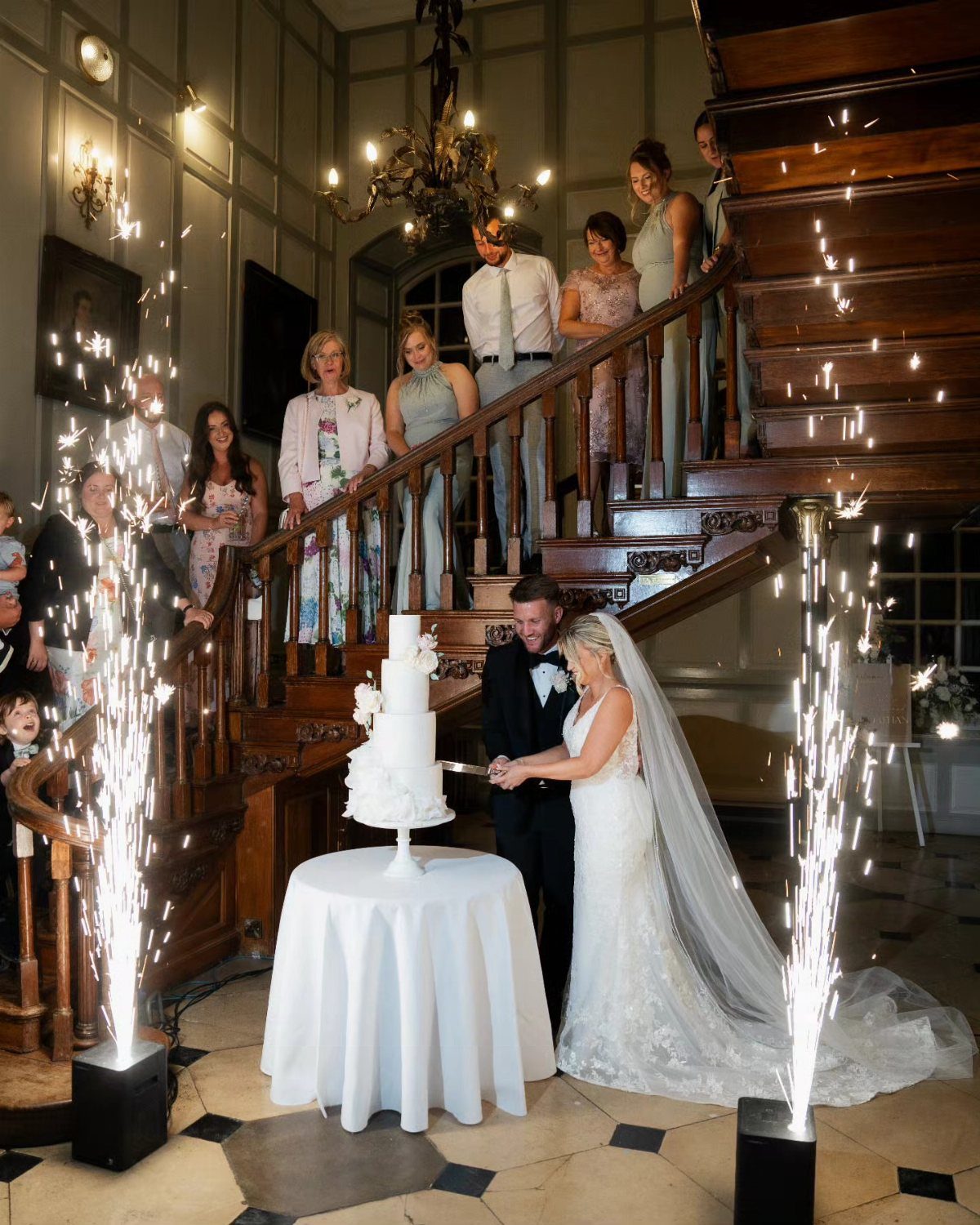 19 Photosession Ideas for Your Wedding Ceremony 10 Bride and groom cutting a white wedding cake surrounded by bright indoor sparklers.