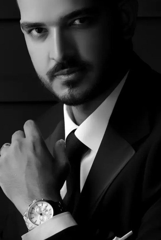 19 Photosession Ideas for Your Wedding Ceremony 7 Man in a dark suit and tie posing for a formal portrait wearing a wristwatch.