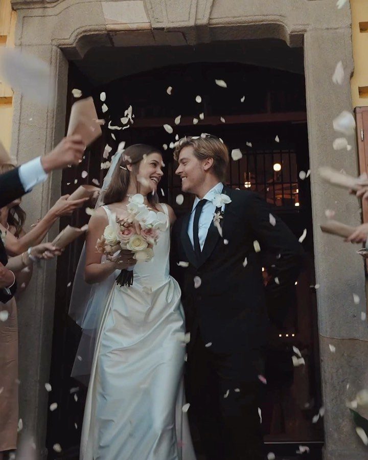 19 Photosession Ideas for Your Wedding Ceremony 12 Bride and groom smiling at each other under falling white flower petals.