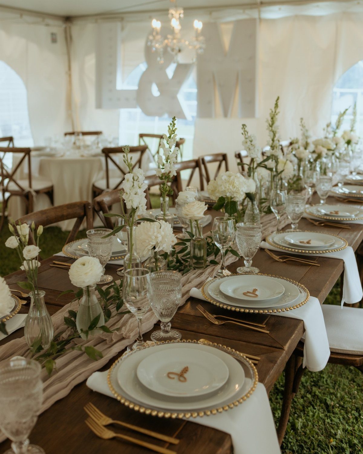 8 Wedding Decor Elegant Ideas for Church and Reception (2026) 3 Elegant wedding table settings with white plates, gold cutlery, and white floral centerpieces on wooden tables.