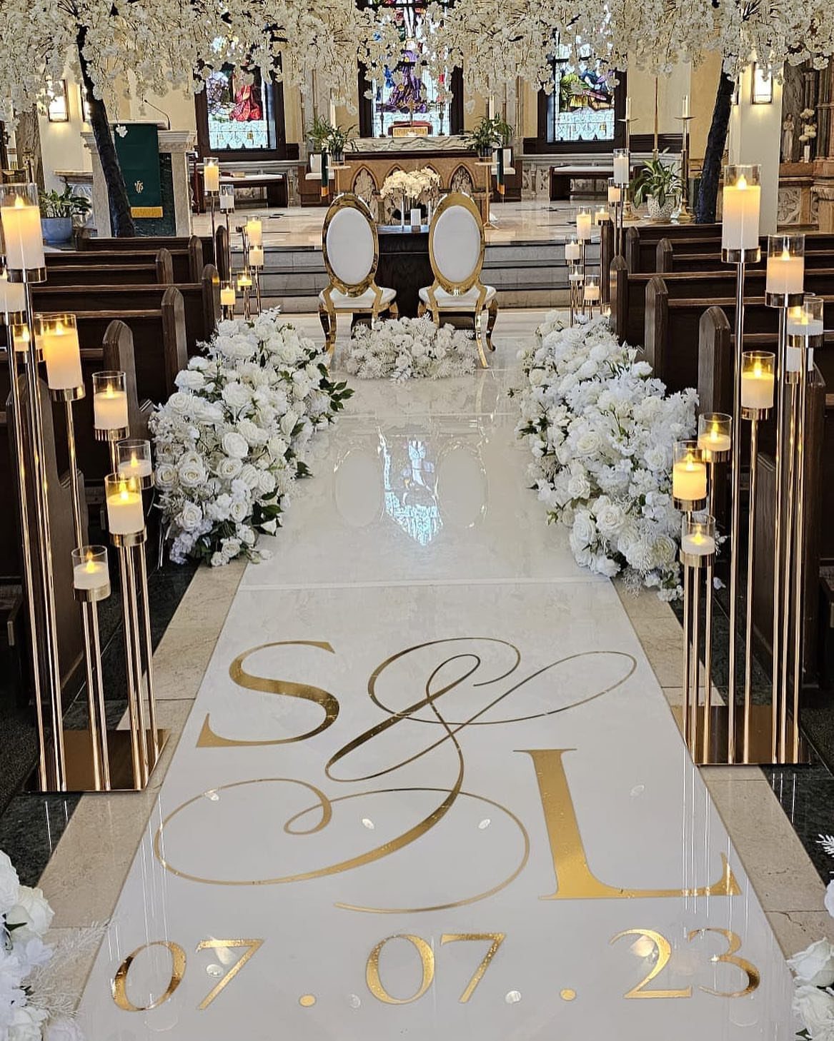 8 Wedding Decor Elegant Ideas for Church and Reception (2026) 7 A white glossy aisle runner with gold lettering and floral arrangements in a church.