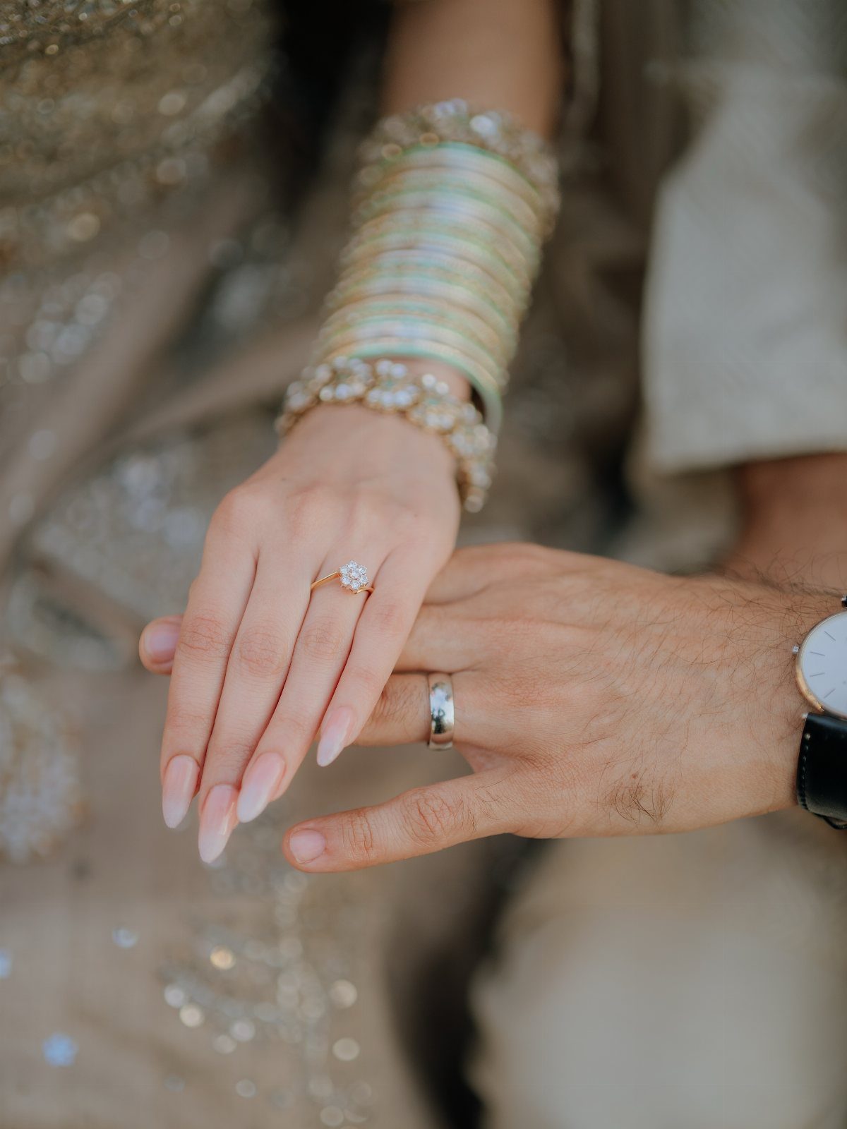 7 Wedding Picture Poses for the First Look, Sunset, and More 7 A person's hand with a diamond ring resting on a partner's hand wearing a silver band.