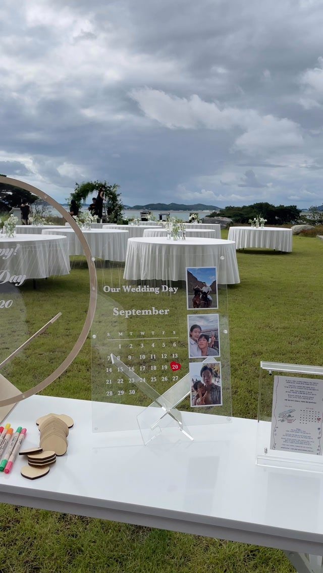 16 Wedding Reception Tables and Layouts for Every Celebration 8 Acrylic wedding sign with photos and markers on a white table outdoors.