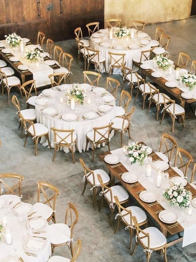 16 Wedding Reception Tables and Layouts for Every Celebration 14 Multiple decorated wedding reception tables with white linens and floral centerpieces arranged in a large hall.