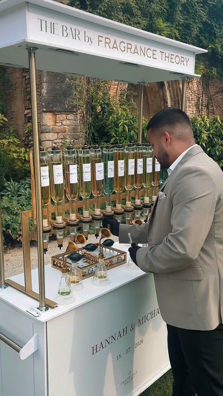 A man in a suit interacts with a professional fragrance station bar outdoors.