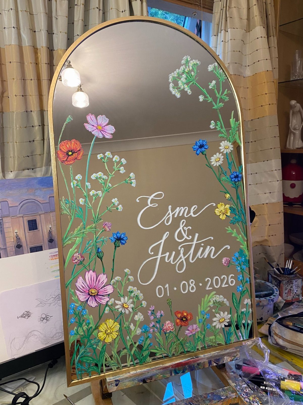 Wildflower Wedding Theme: 13 Ideas for a Light, Natural Day 9 Hand-painted wildflowers and wedding names on a large arched mirror decoration.