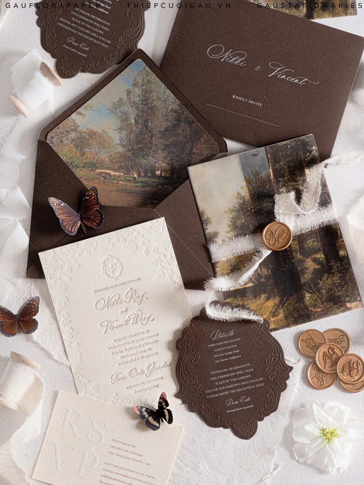 Wedding stationery set with forest landscape cards, brown envelopes, and butterfly decorations.